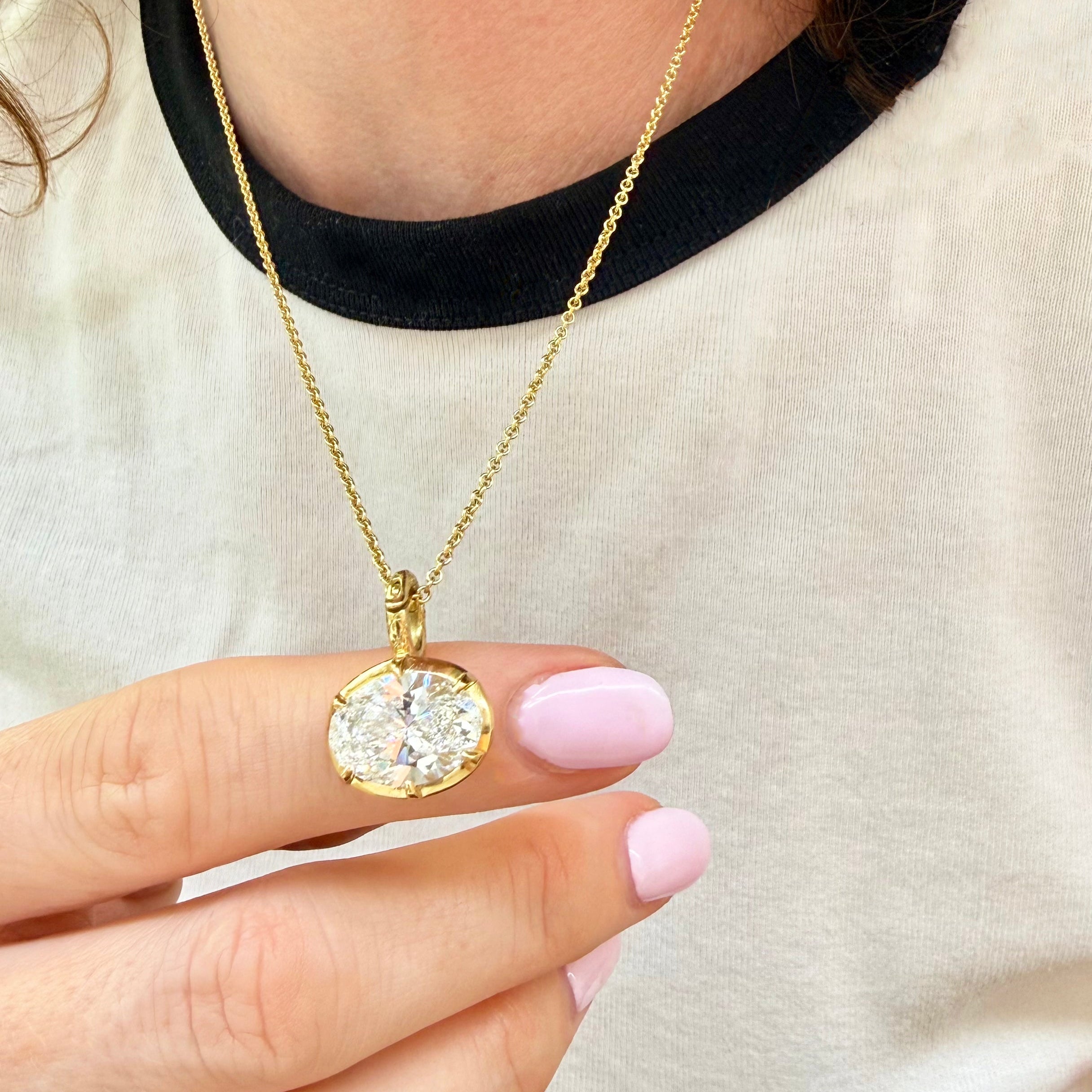 Diamond birthstone pendant on gold chain, worn