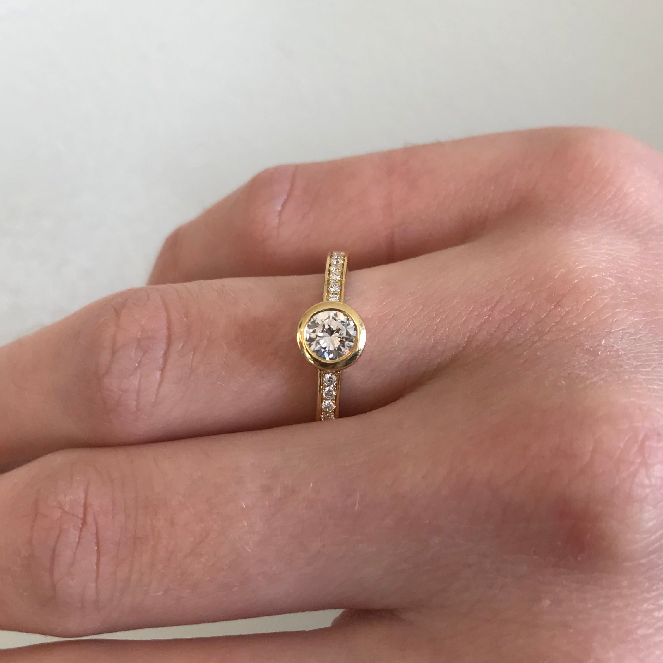 Diamond ring with bezel set shoulders