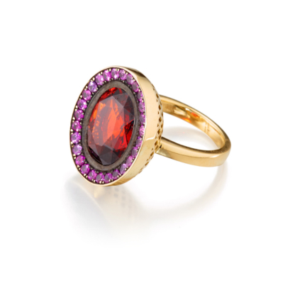 This is the main product image for a north/west set cocktail ring of a garnet ring surrounded by pink sapphires