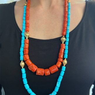 This is an image of a sleeping beauty turquoise necklace layered with a coral necklace