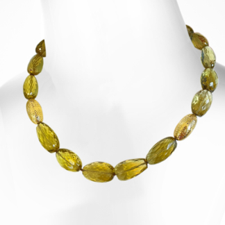 This is an image of tumbled green olive quartz gemstones strung with 2 18k beads
