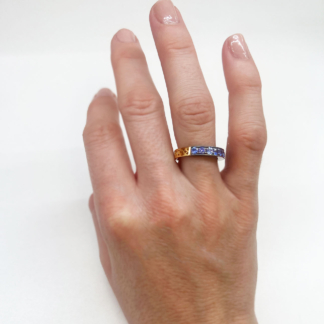 This is a photo of a sapphire band being worn on a ring finger