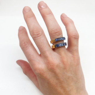This is an image of a color change garnet stacker band paired with a sapphire stacker band on a ring finger