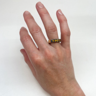 This is an image of a yellow sapphire stacking band being worn on the ring finger