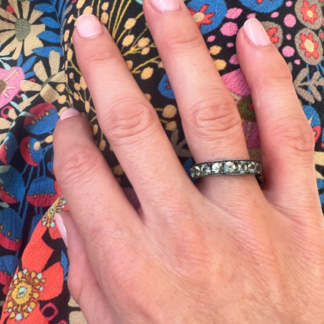 This is a photo of a color change garnet stacker band being worn on the ring finger