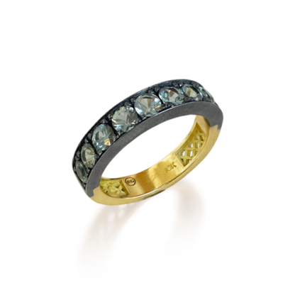This is a product image of a stacker band with color change garnets set in oxidized silver and a yellow gold band