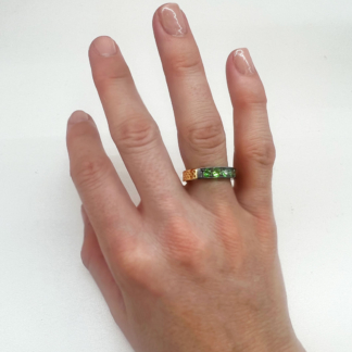 This is an image of a tsavorite stacking band being worn on a ring finger