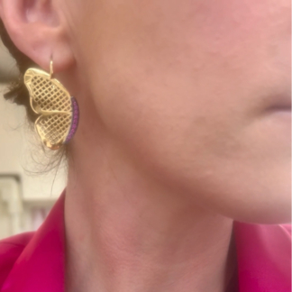 This is a screenshot of the video of a pair of 18k Yellow Gold crownwork® earrings featuring a pave pink sapphire center