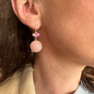 This is an image of pink peruvian opal drop earrings on our model with 4 pink sapphires set in a clover on 18k yellow gold wires