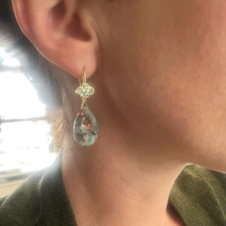 This is a shot of our green sapphire clover top earrings with aquaprase stones being worn to show how they hang on a model
