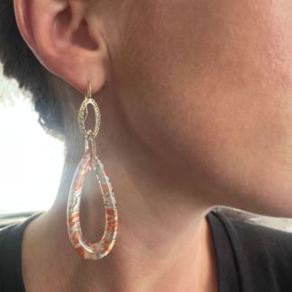 This is an image of our agate frame drop earrings on 18k yellow gold link being work by a model