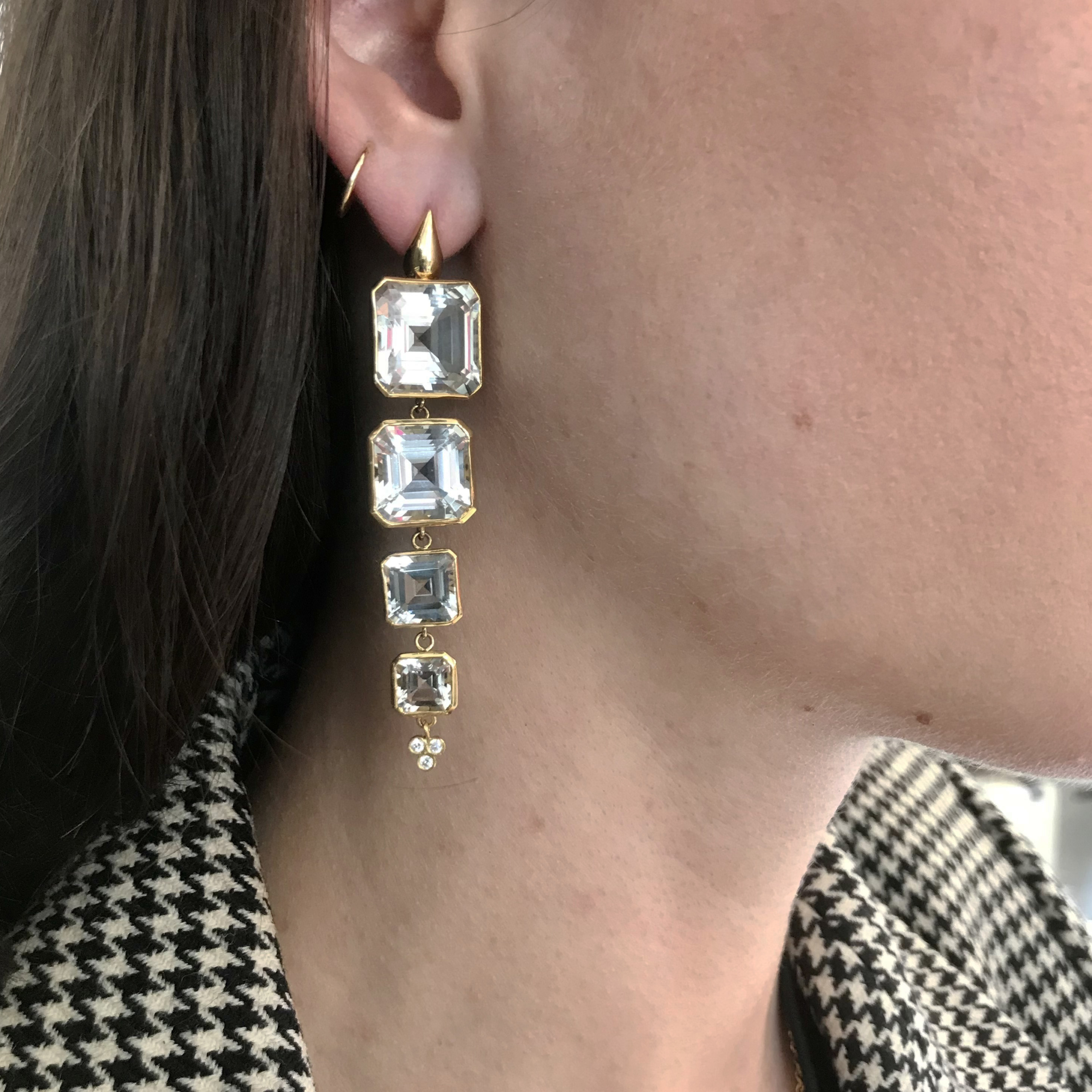 This is a photo of 18k yellow gold Crownwork bezel set emerald cut white topaz earrings on teardrop top posts with 12mm, 9mm + 7mm cascading white topaz drops and triple diamond drops