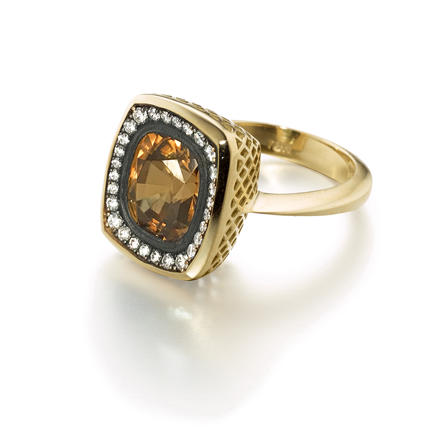 This is a photo of an 18k yellow gold Crownwork cocktail ring with a bezel set cushion cut golden zircon with pave diamond surround in oxidized silver