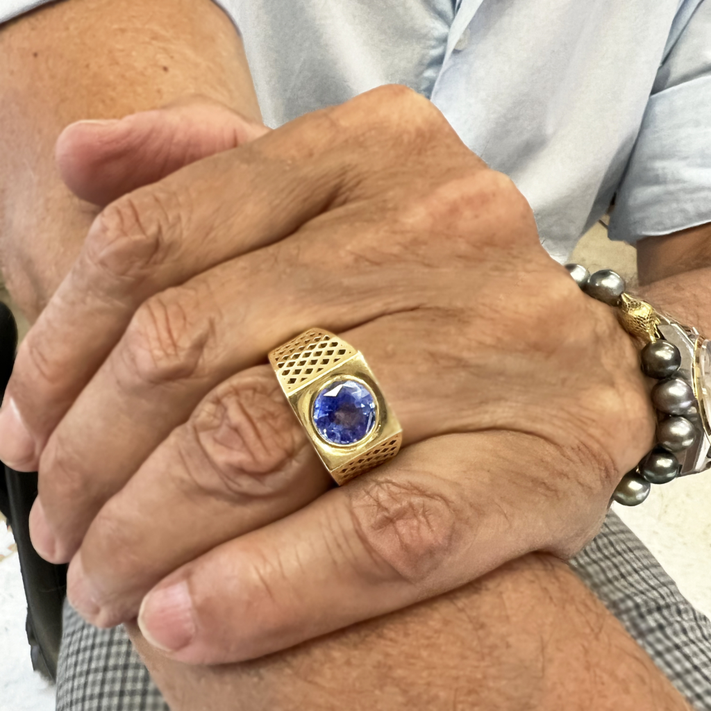 This is a photo of Ray wearing his 18k Yellow Gold Crownwork ring with stunning Blue Sapphire 