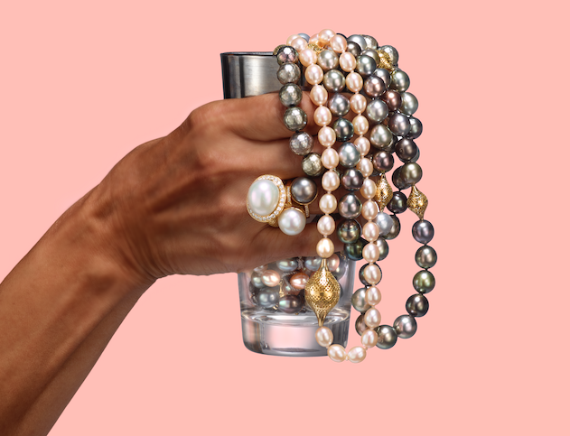 This is a photo of pearl necklaces being held in a glass