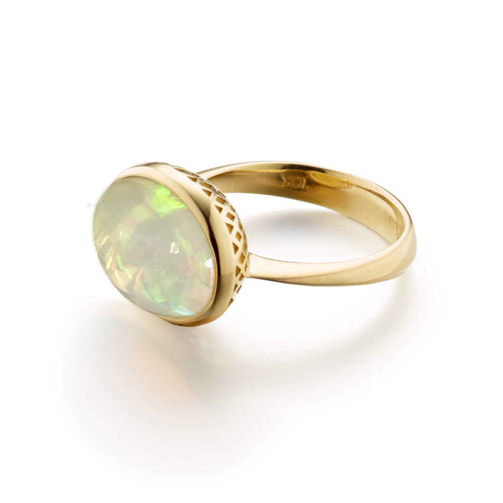 This is photo of an 18k yellow gold crownwork ring with a cabochon opal ring