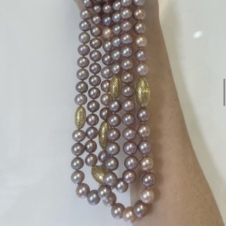 This is a photo of various pearl strands in pinky/purple shades