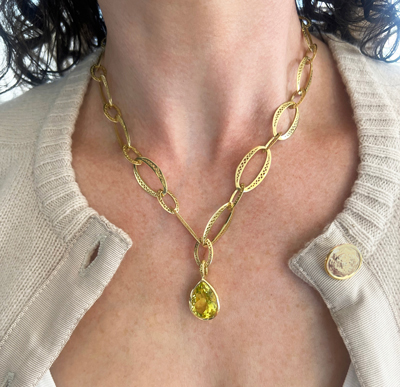 This is a photo of a green citrine pear shaped pendant on a gold chain