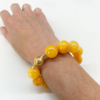 This is a photo of a bright yellow amber beaded bracelet being worn