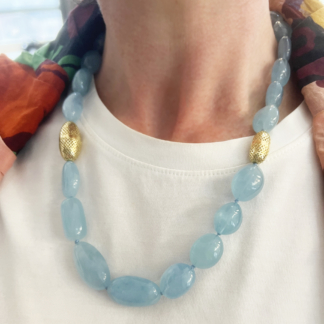 This is an image of an aquamarine necklace being worn with a white t-shirt