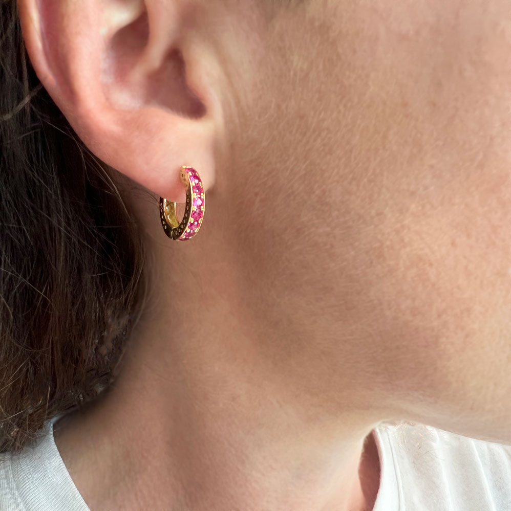 This is a photo of the 18k YG huggie earrings with dark pink sapphires