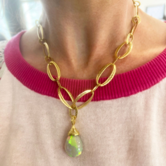 This is a photo of an Ethiopian opal pendant on a gold link chain