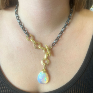 This is a photo of an Ethiopian Opal Pendant on an oxidized silver chain with gold crownwork links
