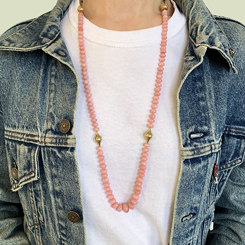 This is a photo of a pink Peruvian opal necklace worn with white T-shirt and denim jacket