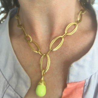 This is a photo of a lemon chrysoprase pendant worn on an 18k yellow gold chain