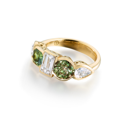 This is a photo of an 18K Yellow gold asymmetric scallop set ring with green sapphire and diamonds.