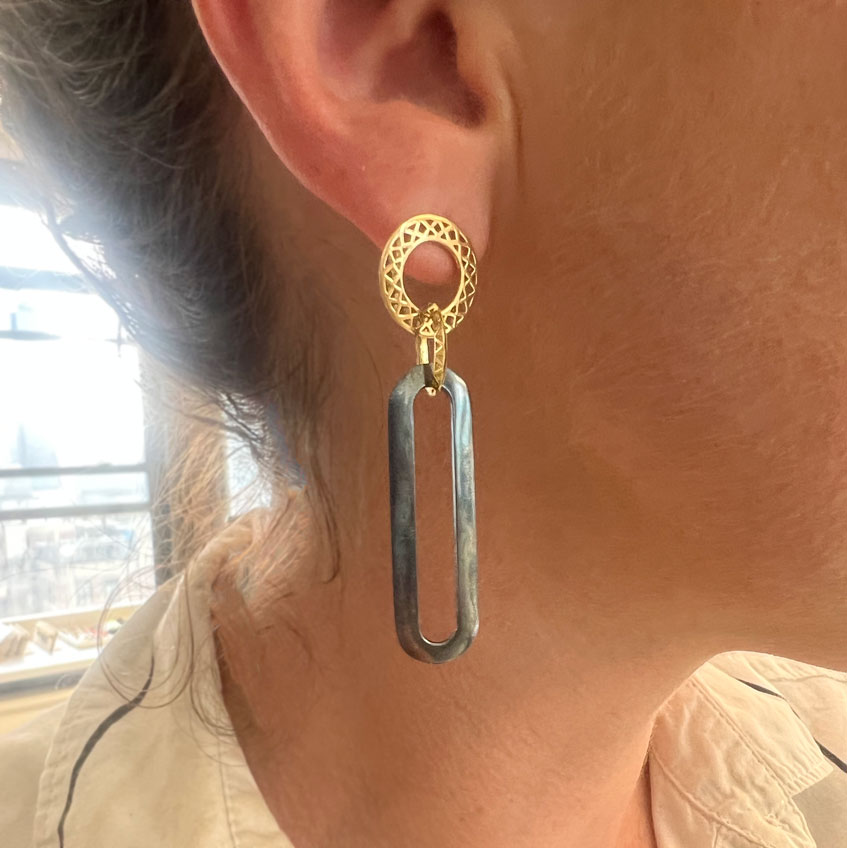 This is an image of a pair of earrings featuring 18k crownwork® disks on a post and oxidized silver link drops being worn