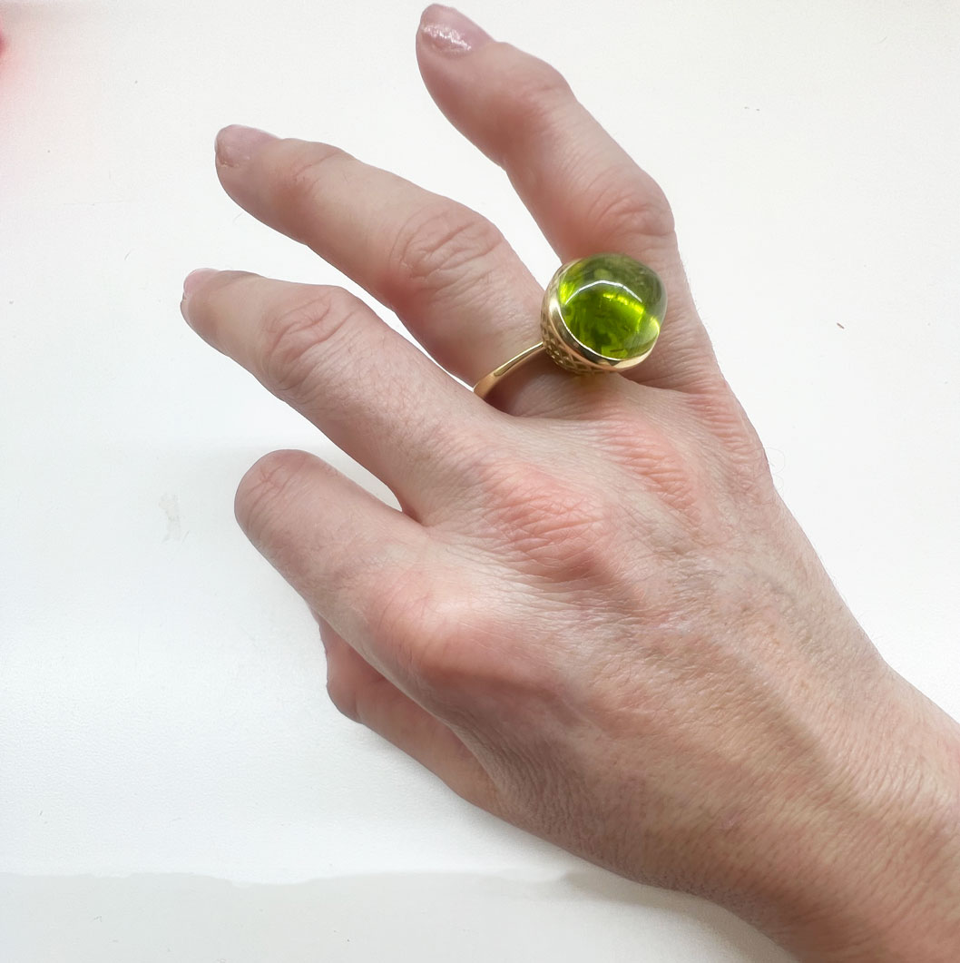 This is a photo of an east west peridot cocktail ring worn on the right hand
